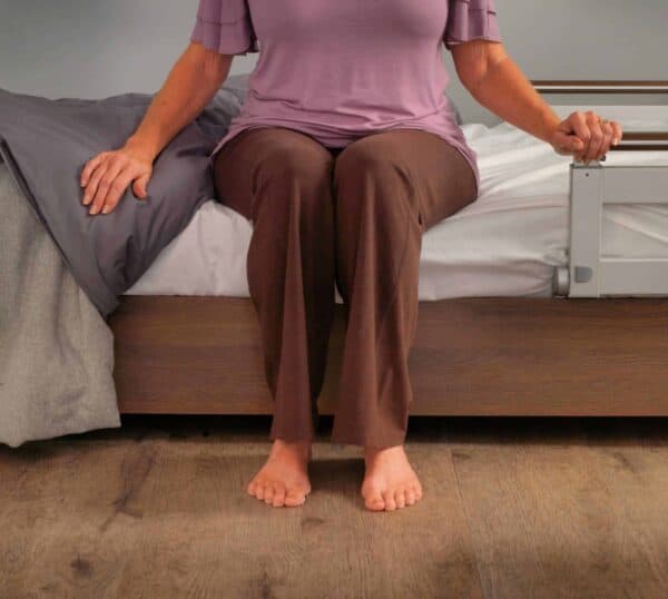 A woman sitting on a bed with an Aura Premium Wide 48 Upwork.