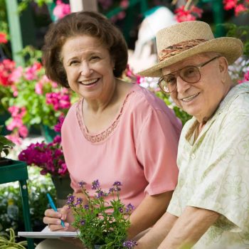 a man and a woman sitting next to each other in a garden.